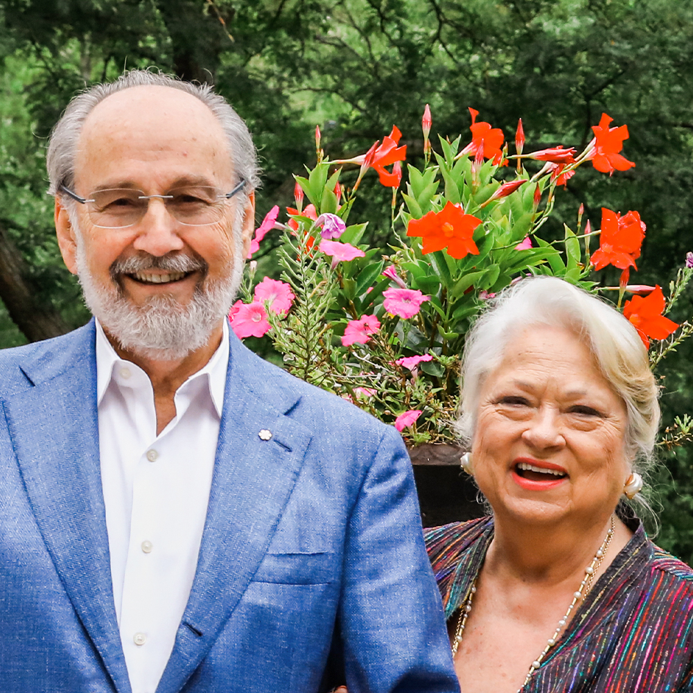 James and Louise Temerty laugh together in a garden.